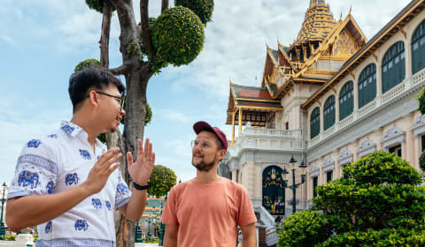 A local guide with a tourists at the Grand Royal Palace in Bangkok