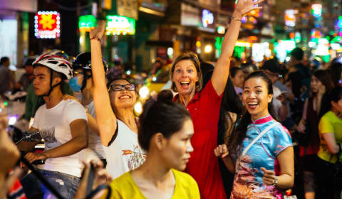 A tourist posing with the locals on the streets of Ho Chi Minh city in the night