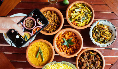 A top down view of Sri Lankan food with someone making a picture with a view above the food