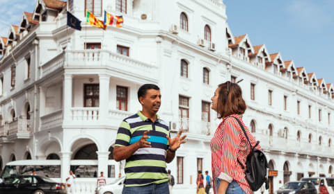 A local guide telling a story to a tourist on the streets of Colombo