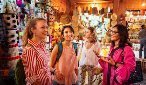 A local guide telling a story to a group of tourists in the Souks of Marrakech