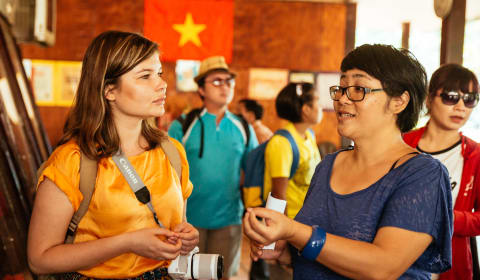 A local guide telling a story to a tourist about the Cu Chi Tunnels, Viet Cont and the Vietnam war