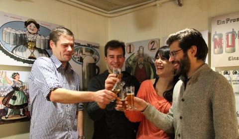 Four people cheering with Bavarian beer