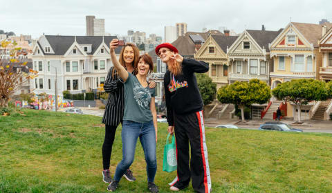 A family posing for a picture in front of the Painted Ladies in San Francisco