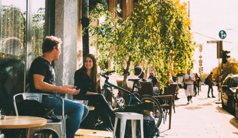 Two people sit on a terrace