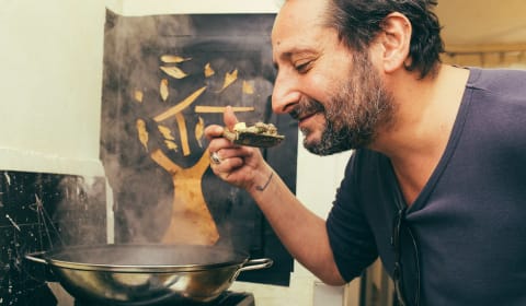 A local chef smelling food above the stove in a Parisian home dinner