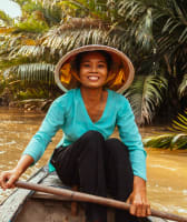 Vietnamese local rowing a boat at the Mekong Delta